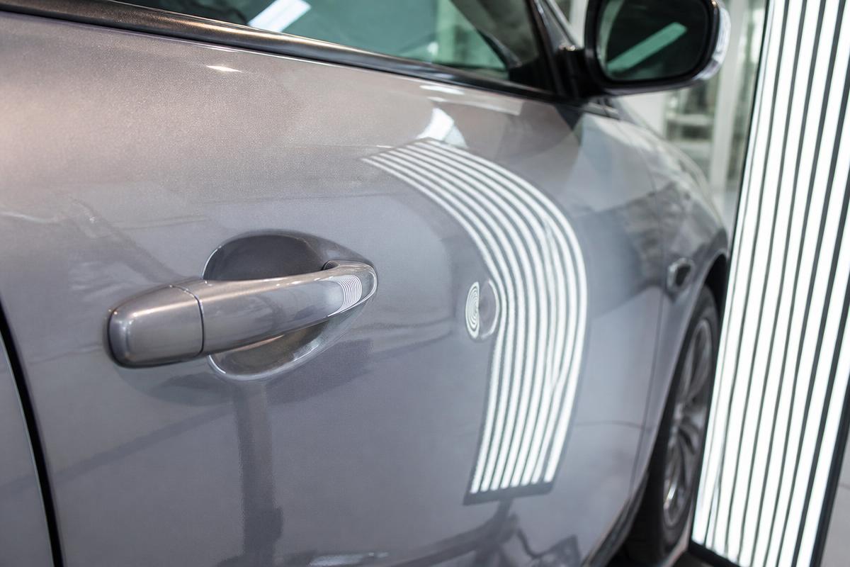 Panel reading light board revealing a door ding on a silver car door